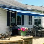 Blue retractable awning on a white house.