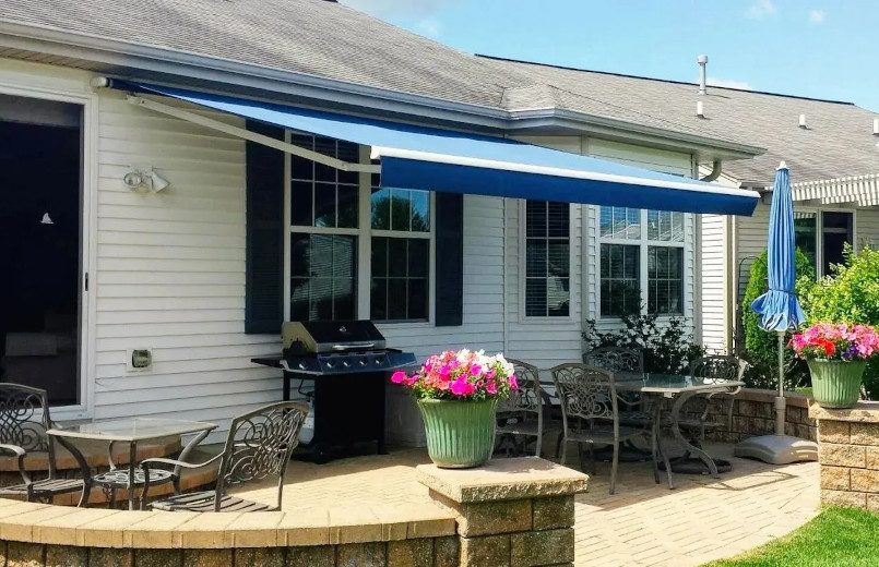 Blue retractable awning on a white house.
