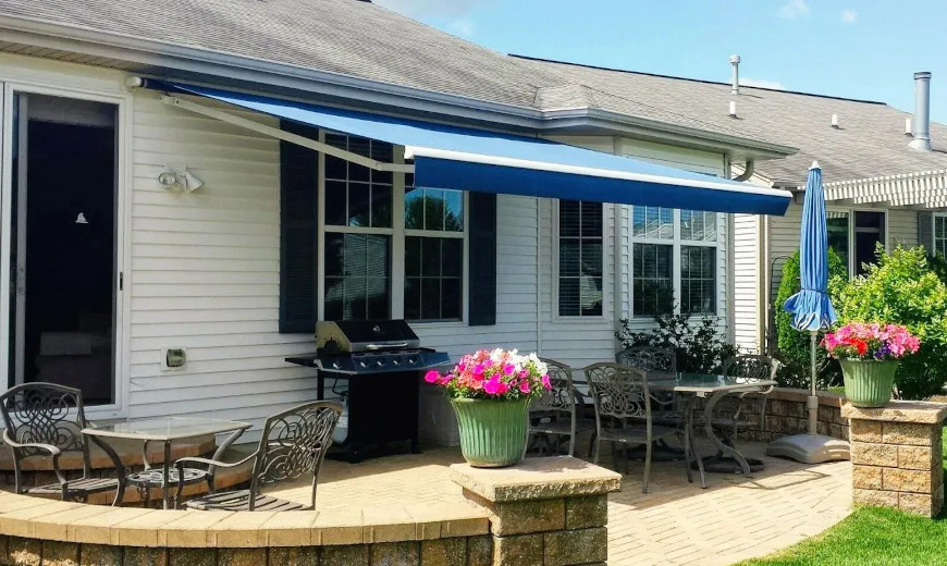 Blue retractable awning on a white house.