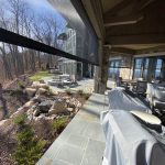 Custom retractable screens enclosing a outdoor porch with stone columns in South Carolina